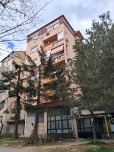 an apartment building with trees in front of it at Mustache 3 Room Apt City Center in Bitola