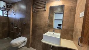 a bathroom with a sink and a toilet and a mirror at M Beach Resort in Colva +23 photos