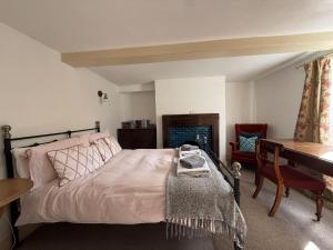a bedroom with a bed and a desk and a table at Two Sides Cottage in Lymington