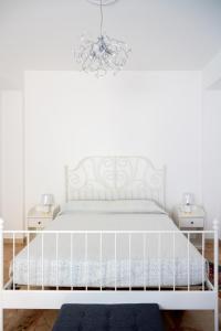 a white bed in a bedroom with two night stands at Da DOMITILLA in centro storico con panorama in Avola