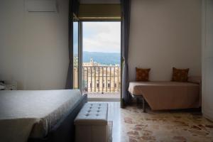 a room with a bed and a couch and a window at Da DOMITILLA in centro storico con panorama in Avola