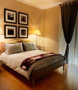 a bedroom with a large bed and some pictures on the wall at B&B La Littorina - Parcheggio Privato in Foligno