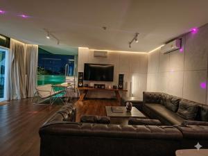 a living room with a couch and a flat screen tv at The Lakeside Sanctuary in Ban Mae Cho
