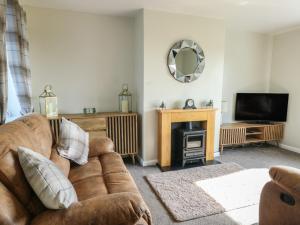 a living room with a couch and a fireplace at Pentre Iago in Holyhead