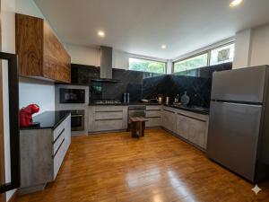 a kitchen with stainless steel appliances and wooden floors at The Lakeside Sanctuary in Ban Mae Cho