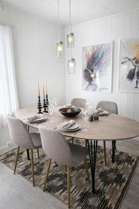 a dining room with a wooden table and chairs at Senja Sjøtun House in Senja