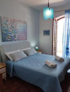 a bedroom with a blue bed with two pillows on it at Brezza Marina & L'oasi Blu in Castelsardo