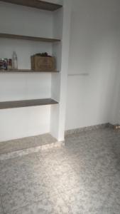 a room with a white wall and a shelf at Landmark Residency in Atirāmpattinam