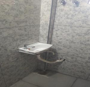 a bathroom with a sink in a tiled wall at Landmark Residency in Atirāmpattinam +11 photos