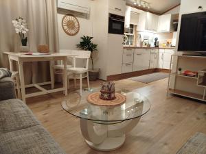 a living room with a glass table and a kitchen at Chalet-Urlaubsglück am See in Lathum