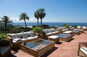 a group of couches and tables on a patio at La Casita - Boutique Retreat Barcelona Coast Sea View in Sant Andreu de Llavaneres
