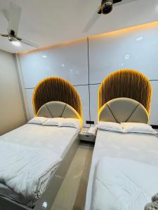 two beds sitting next to each other in a room at Hotel RK in Ujjain