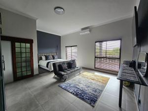a living room with a bed and a couch in a room at Namloom Guesthouse in Pretoria