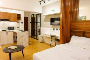a bedroom with a bed and a small kitchen at Chill Studio w Balcony & Free Pool Lapu-Lapu in Mactan Island
