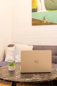 a laptop computer sitting on a table with a couch at Chill Studio w Balcony & Free Pool Lapu-Lapu in Mactan Island