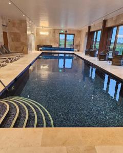a large swimming pool in a large building at Asquith Hall Hotel & Spa Scarborough in Scarborough