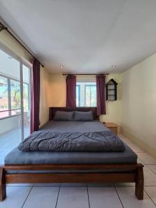 a bedroom with a large bed with red curtains at Pool Villa 25 in Ban Nong Pru +15 photos