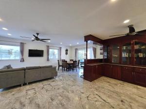 a living room with a couch and a dining room at Pool Villa 25 in Ban Nong Pru