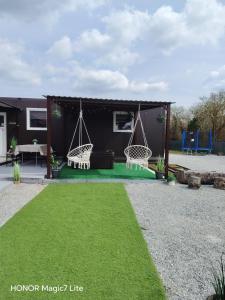 a house with two swings and a grass yard at Apartman SOKAK in Satnica