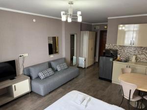 a living room with a couch and a table and a kitchen at ORBI 4 Seasons ApartHotel in Batumi