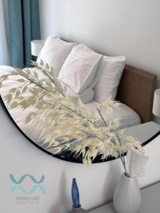 a round mirror on a bed in a room at Római Ház Apartman in Siófok