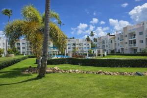a park with palm trees and buildings in the background at Sol Tropical apartamentos in Punta Cana