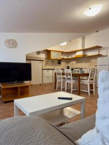 a living room with a table and a kitchen at Sole & Mare in Montesilvano