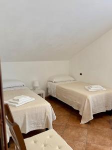 a room with two beds with white sheets and a chair at Sole & Mare in Montesilvano +11 photos