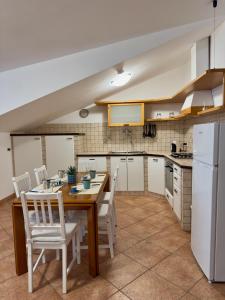 a kitchen with a wooden table and white chairs at Sole & Mare in Montesilvano