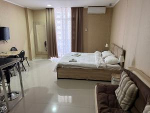a bedroom with a bed and a desk in it at ORBI 4 Seasons ApartHotel in Batumi