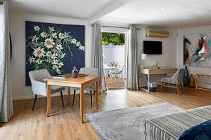 a living room with a table and a painting on the wall at Mirabelle Guesthouse in Franschhoek