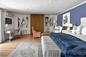 a bedroom with a large bed and a desk at Mirabelle Guesthouse in Franschhoek