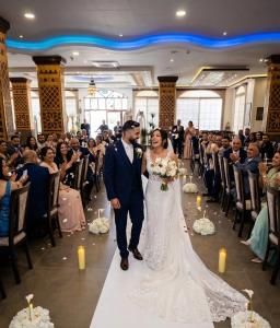 a bride and groom walking down the aisle at their wedding at Petra Canyon Hotel in Wadi Musa