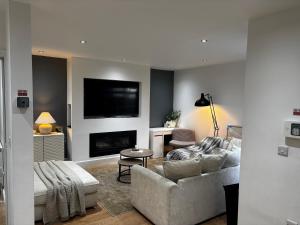 a living room with a couch and a fireplace at Holdsworth House Apartments in Killingbeck