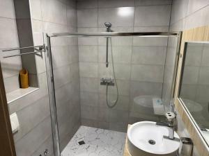a bathroom with a shower and a sink at ORBI 4 Seasons ApartHotel in Batumi +40 photos