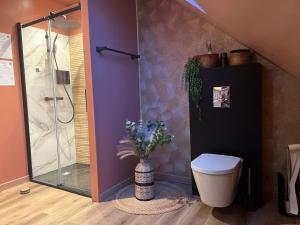 a bathroom with a toilet and a shower with purple walls at Suite La Clé de la Liberté Maison Like and Love 25m2 avec coin salon in Duclair
