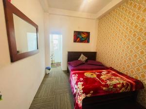 a bedroom with a bed and a mirror on the wall at Ivery guest house in Pattipola