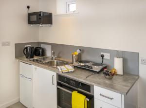 a kitchen with a sink and a stove top oven at The Bake House in Worthing