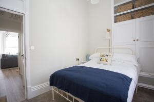 a white bedroom with a bed with a sign on it at Seaways Apartment in Worthing