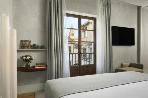 a bedroom with a bed and a window at NH Collection Palacio de Córdoba in Córdoba