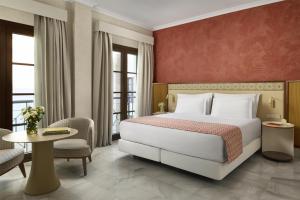 a hotel room with a bed and a table and chairs at NH Collection Palacio de Córdoba in Córdoba +40 photos