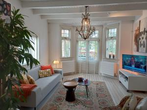 a living room with a couch and a tv at Ons Buiten in Bergen