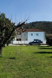 a car parked in a yard next to a house at Casa das Agras in Souto