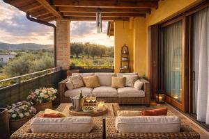 a patio with a couch and a table on a balcony at Sunshine Luxury Apartment - spacious house - Lake View - Pool in Padenghe sul Garda