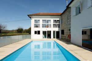 a swimming pool in front of a house at Casa das Agras in Souto