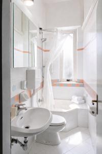 a white bathroom with a toilet and a sink at Hotel ABA FRONTE MARE in Milano Marittima