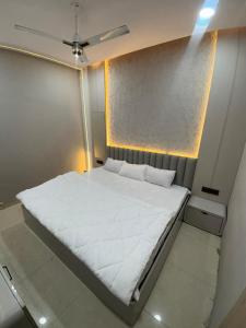 a large white bed in a small room at Hotel RK in Ujjain