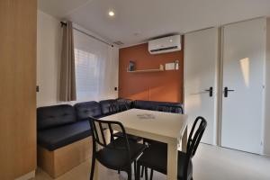 a dining room and living room with a table and chairs at Vertacoflav - Bungalow - 6 couchages in Carry-le-Rouet