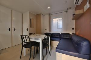 a living room with a couch and a table and chairs at Vertacoflav - Bungalow - 6 couchages in Carry-le-Rouet