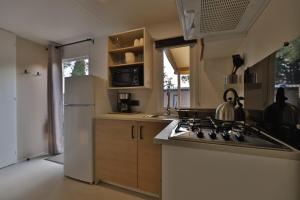 a kitchen with a stove and a white refrigerator at Vertacoflav - Bungalow - 6 couchages in Carry-le-Rouet
